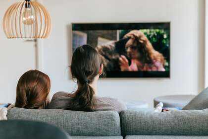 Une adulte et une enfant qui regardent la télévision