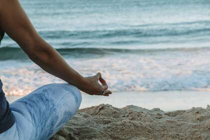 Une personne faisant du yoga sur une plage